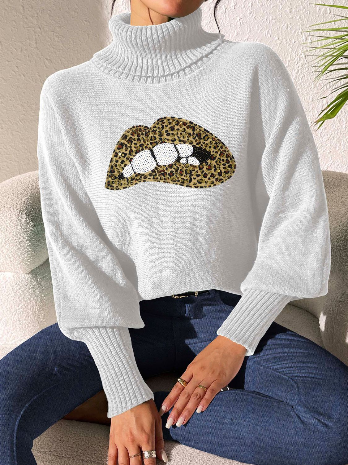 White turtleneck sweater with sequin leopard print lips detail and balloon sleeves.