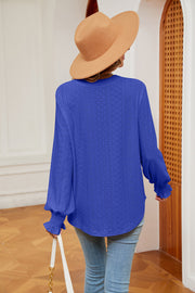 Royal blue eyelet blouse with poet sleeves and ruffled cuffs.