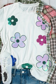 White t-shirt with colorful sequin floral appliqués and a plaid shirt overlay.