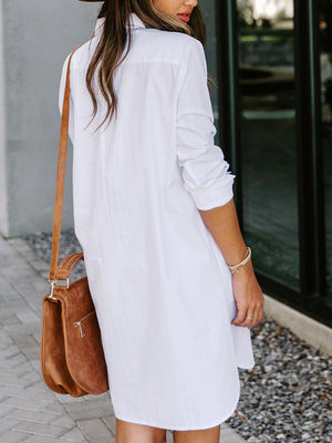 Oversized white cotton shirt dress with button front and curved hem.