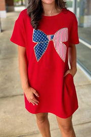 Red cotton mini dress with a stars and stripes bow applique and pockets.