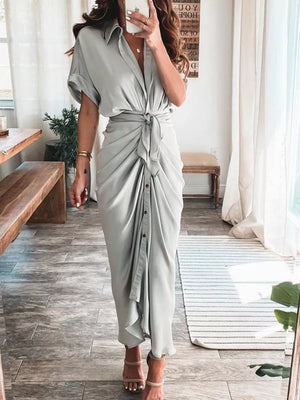 Elegant tie-waist midi dress in light gray with button detail and short sleeves.