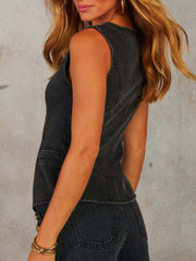 Dark denim vest with asymmetric closure and button details.