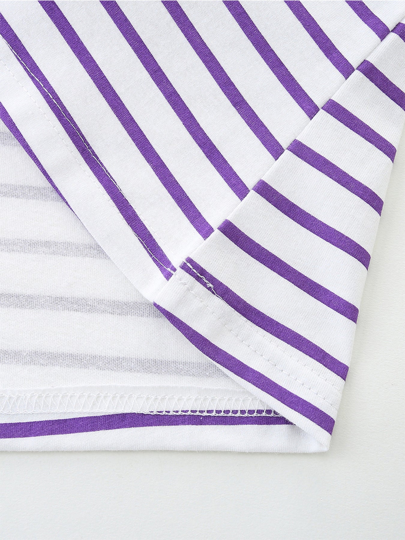 Baby dress with purple and white stripes, cotton fabric, close-up of hem and seams.