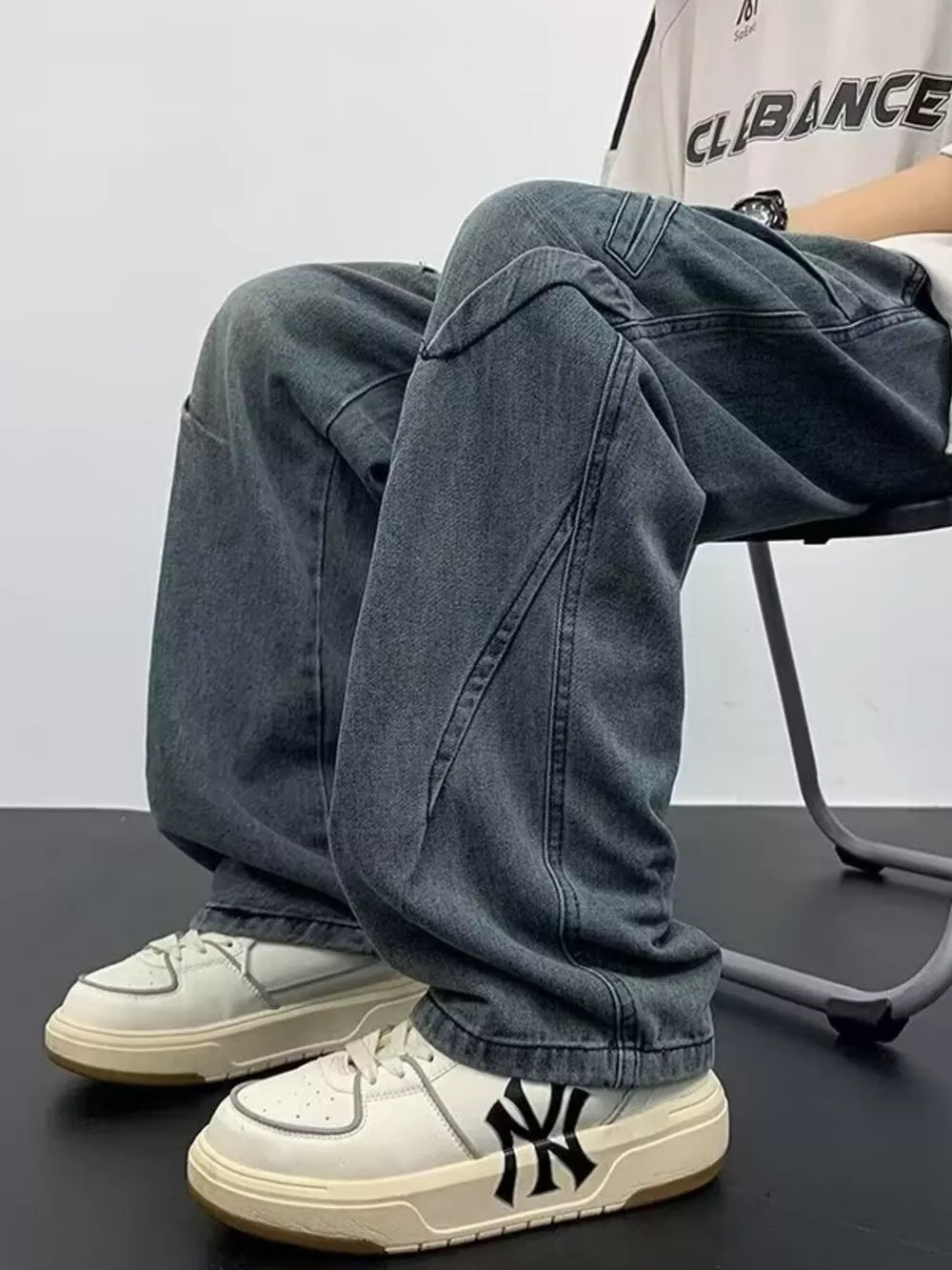 Gray oversized drawstring jeans with contemporary stitching detail.