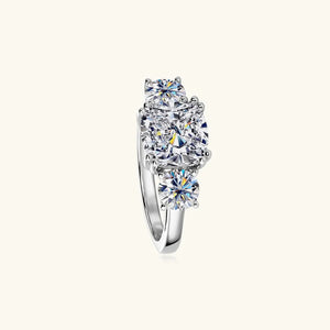 Silver three-stone cushion cut moissanite ring with round side stones.