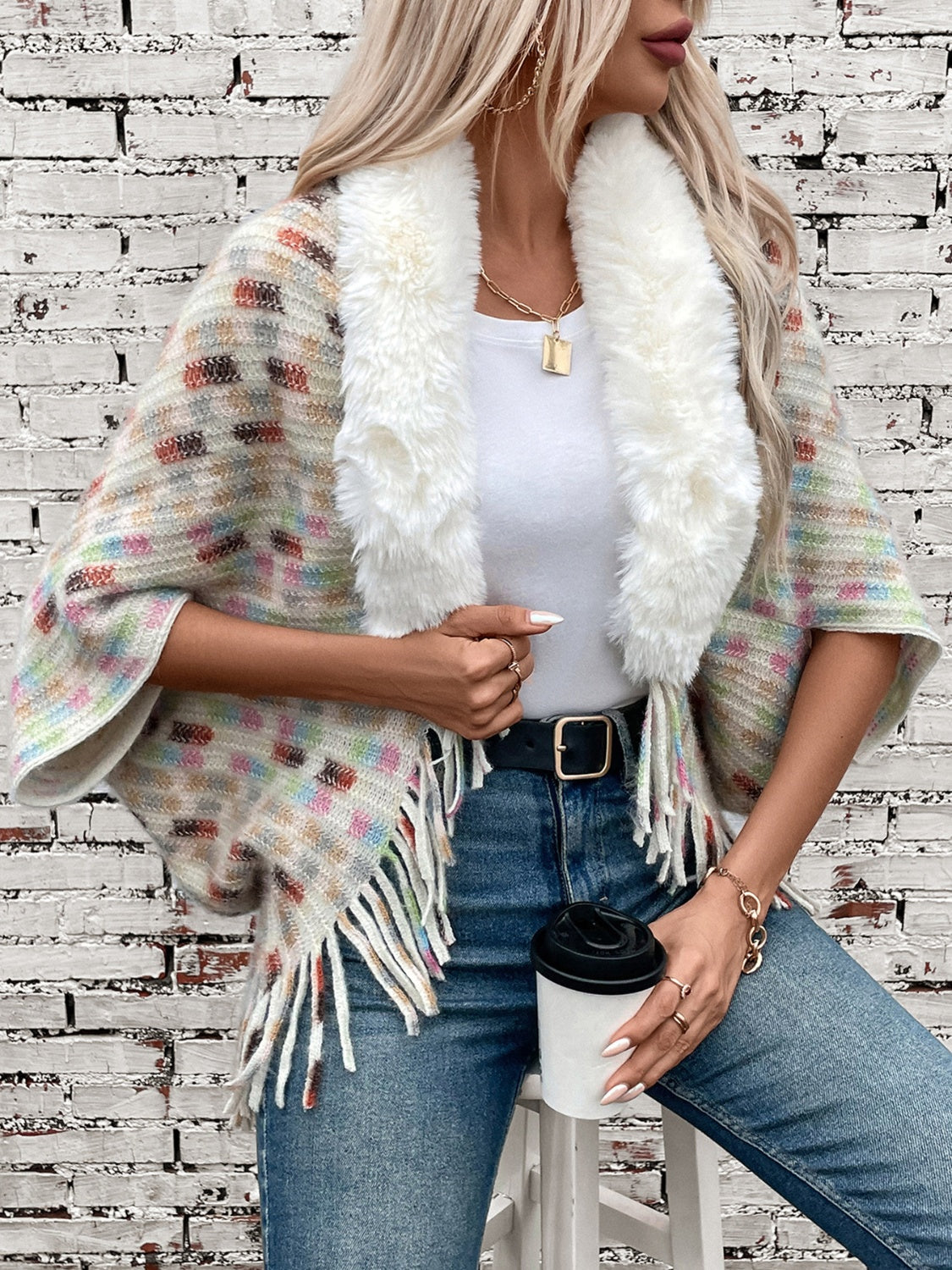 Textured plaid acrylic poncho with faux fur collar and fringe details.