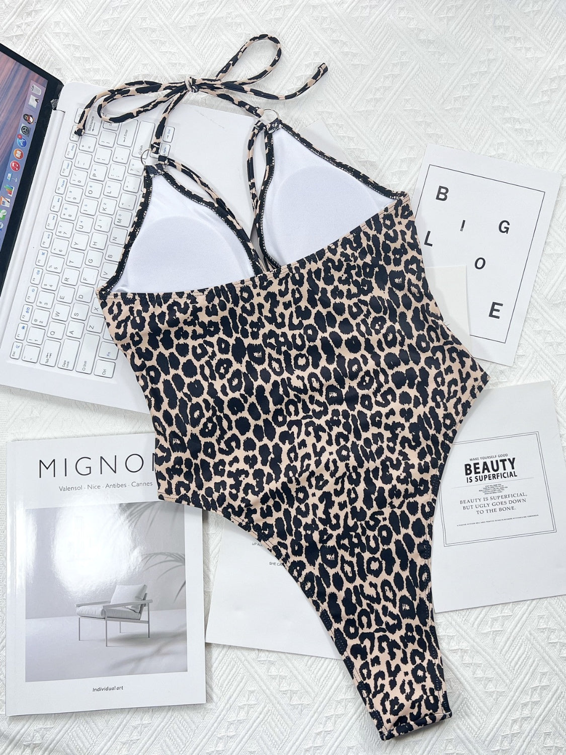 Leopard print one-piece swimsuit with ring detail and halter neck.