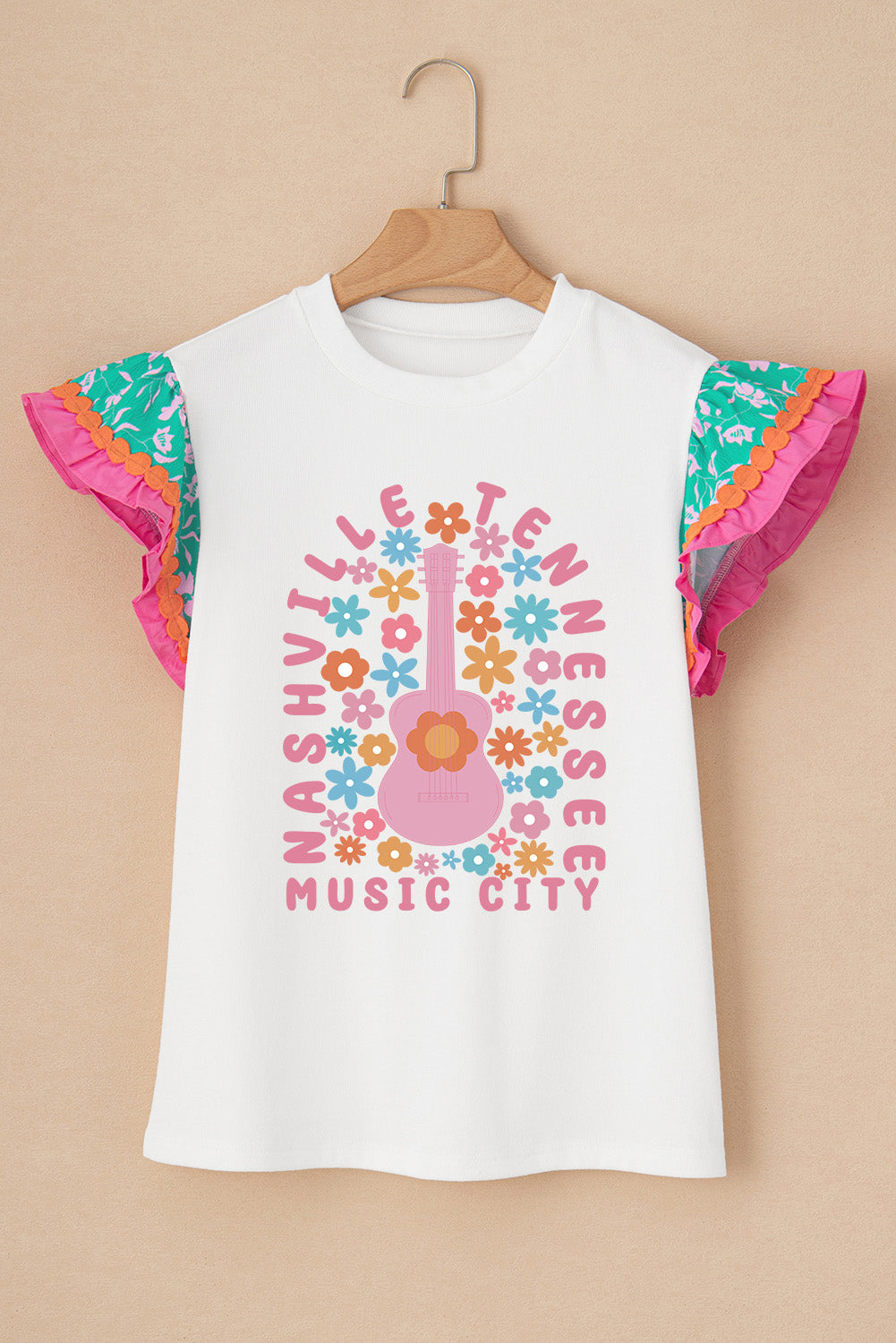 White graphic tee with ruffle sleeves, featuring a pink guitar and flowers with Nashville Music City text.