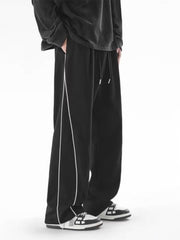 Men's black relaxed fit sweatpants with white side stripes and drawstring waist.