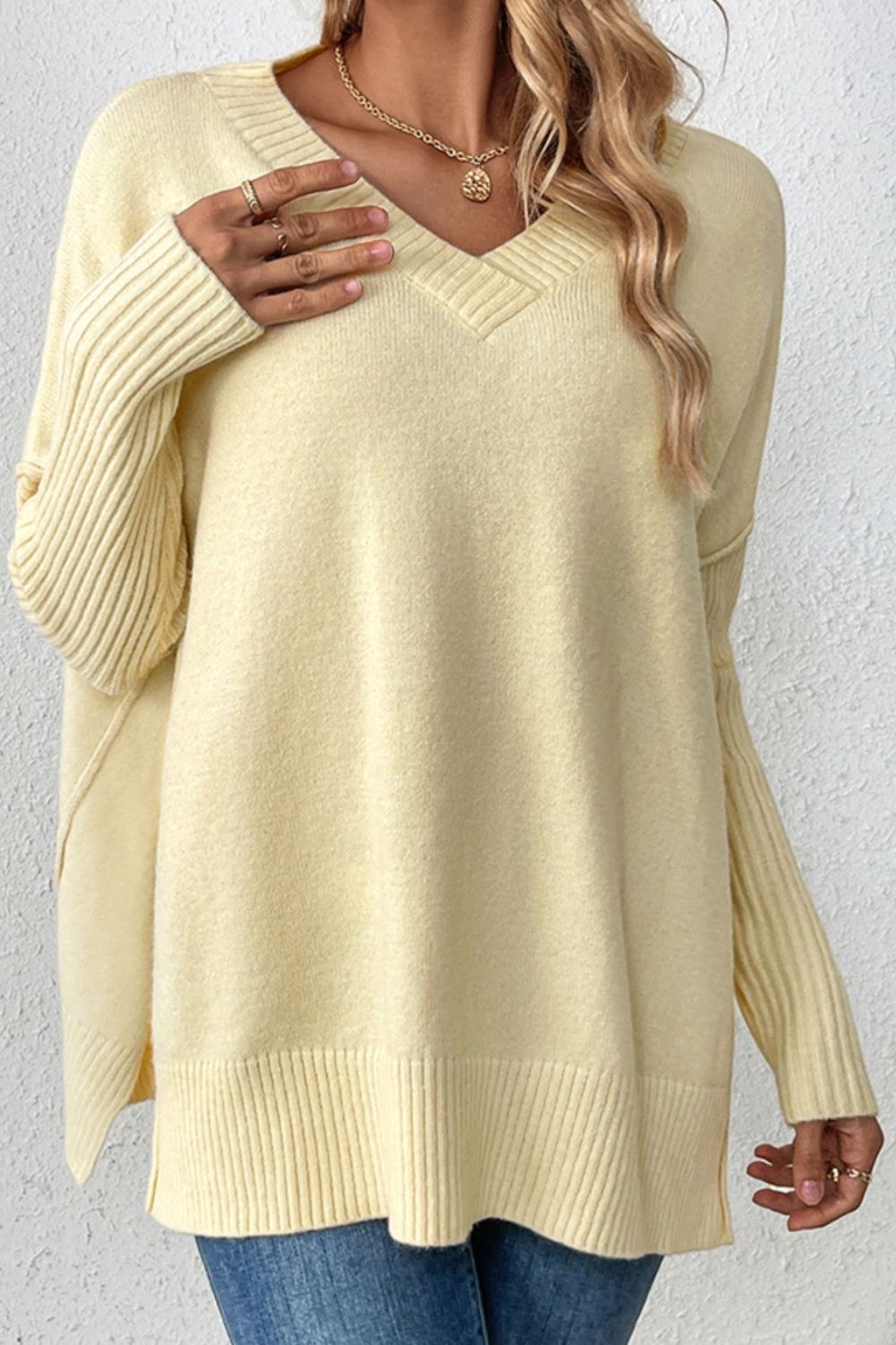 Light Yellow V-neck knit sweater with asymmetric hemline and ribbed sleeves.