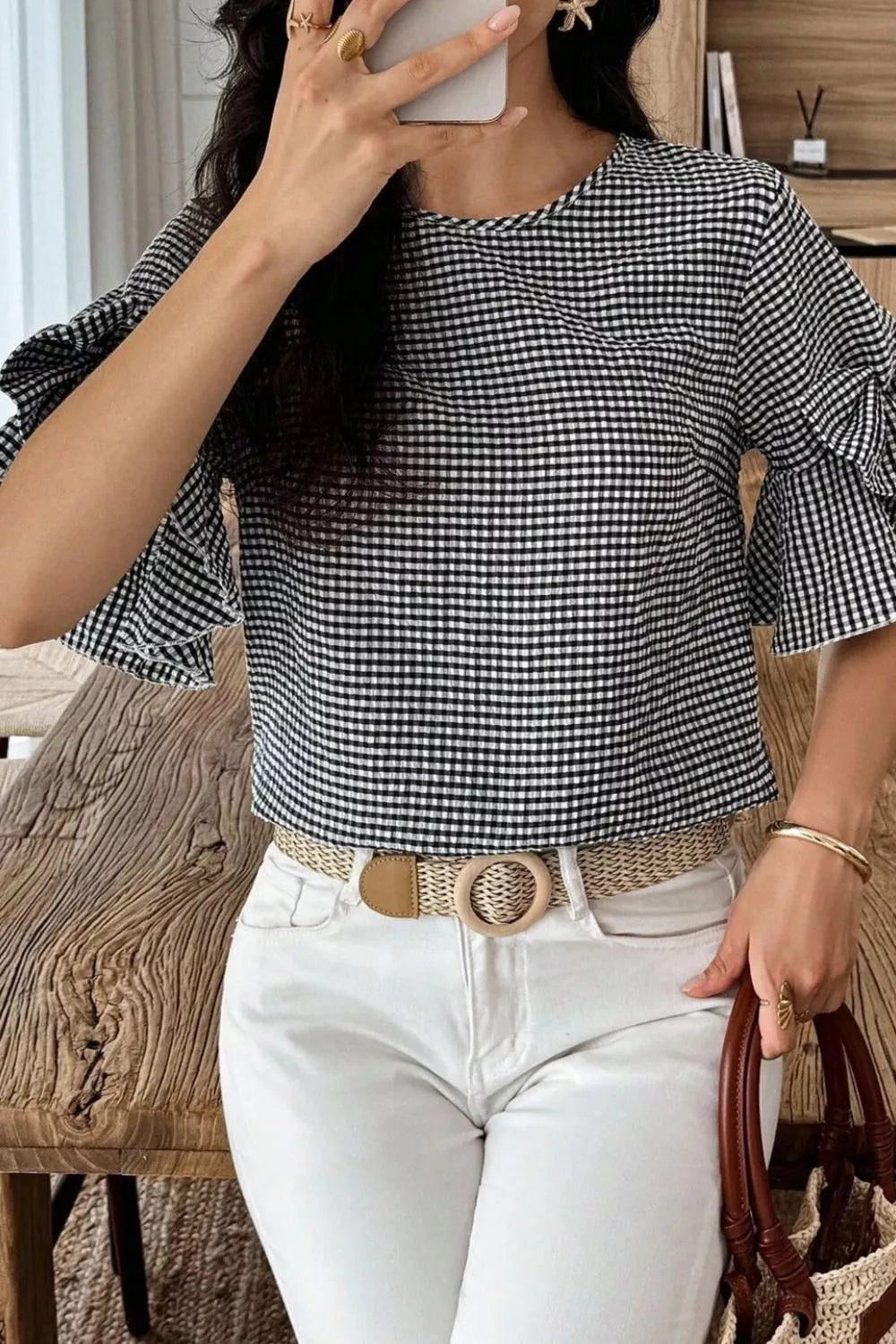 Black and white gingham polyester shirt with ruffled sleeves and a round neckline.