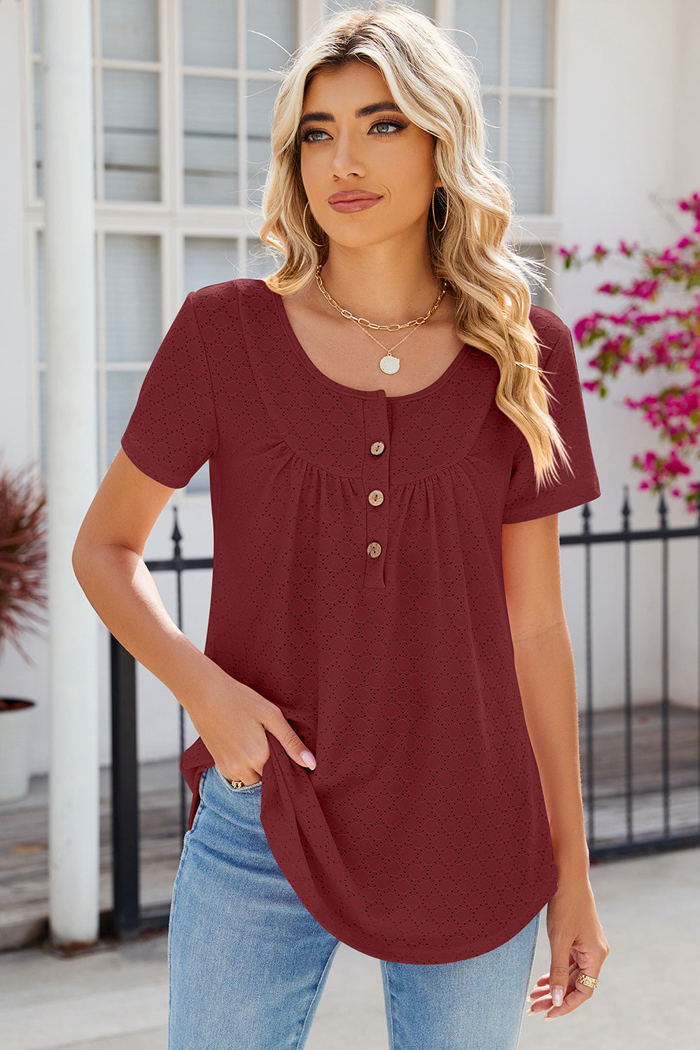 Rust eyelet yoke gathered henley shirt with button detail and short sleeves.