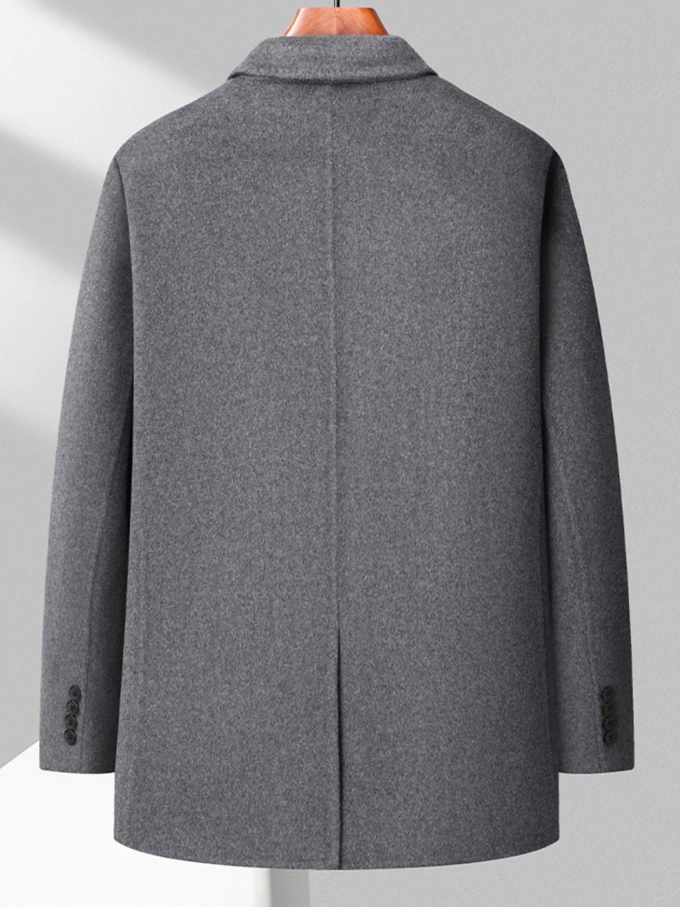 Men's gray wool long-sleeve overcoat with button cuffs and a center back vent.