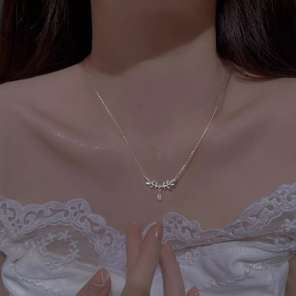 Elegant silver zircon flower pendant necklace with delicate leaf design and a single teardrop crystal.