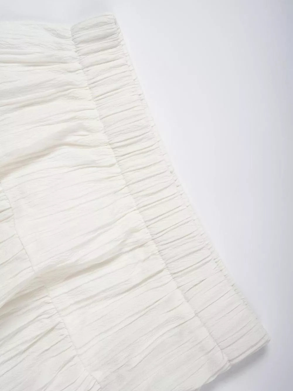 White tiered maxi skirt with elastic waistband and textured fabric detail