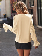 Sand polyester blouse with ruffled cuffs and shoulders, long sleeves.