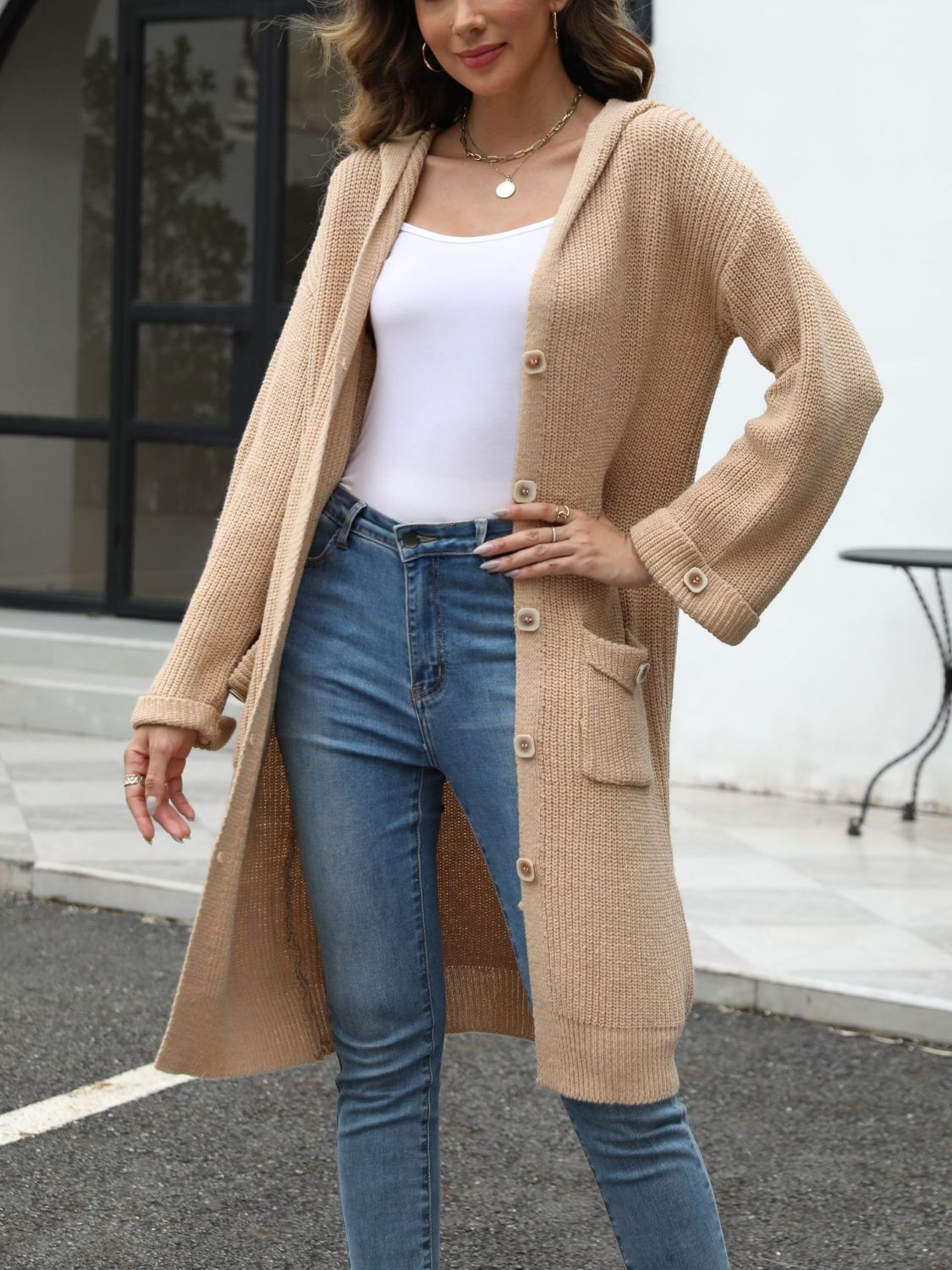 Longline tan knit cardigan with hood, buttons, and pockets.