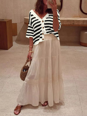 Cropped black and white striped knit cardigan with V-neck and buttons.