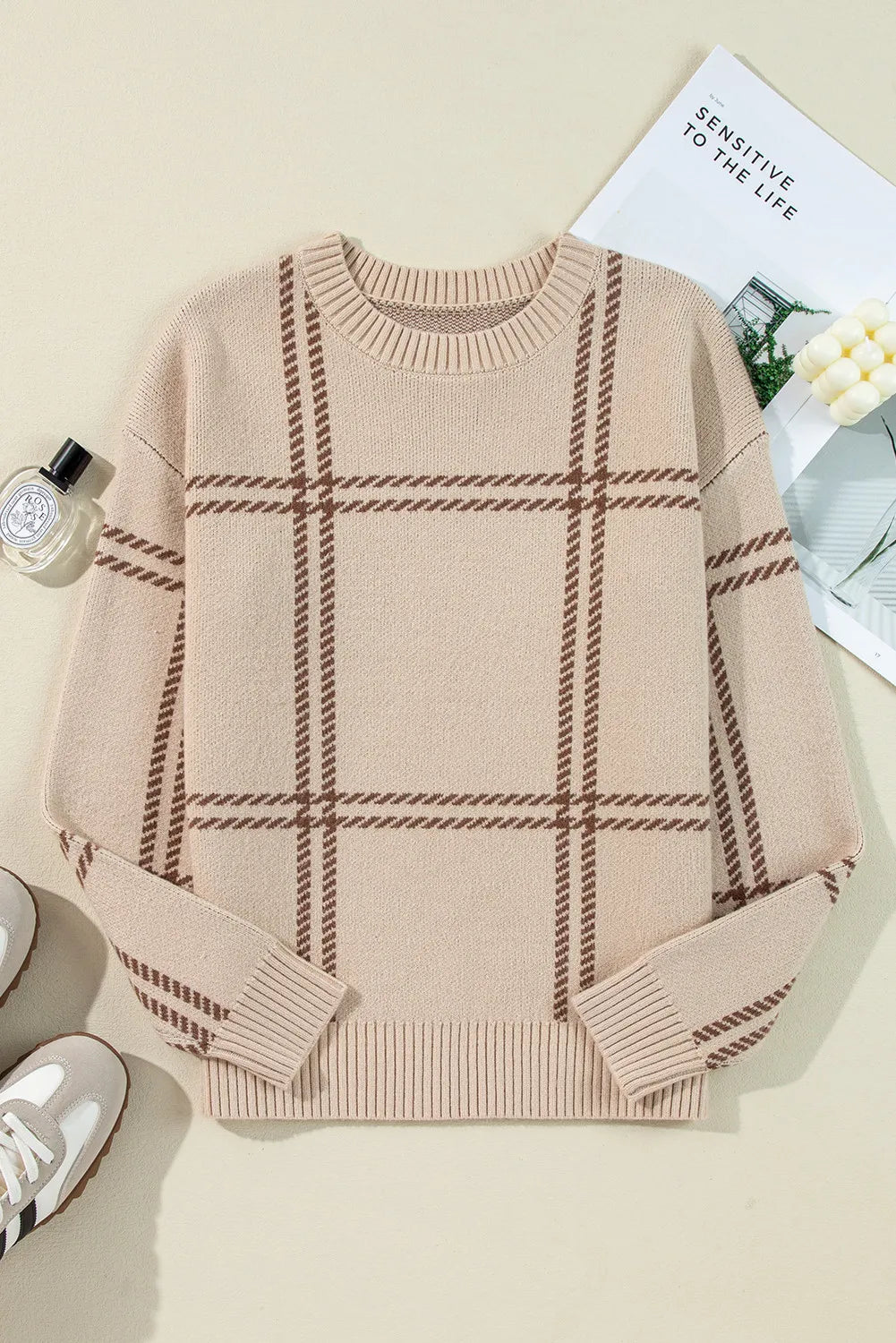 Tan crewneck knit pullover sweater with brown plaid pattern and ribbed cuffs.