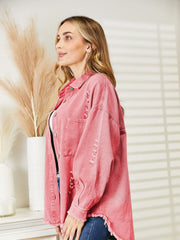 Distressed denim overshirt in blush pink with raw hem and button details.