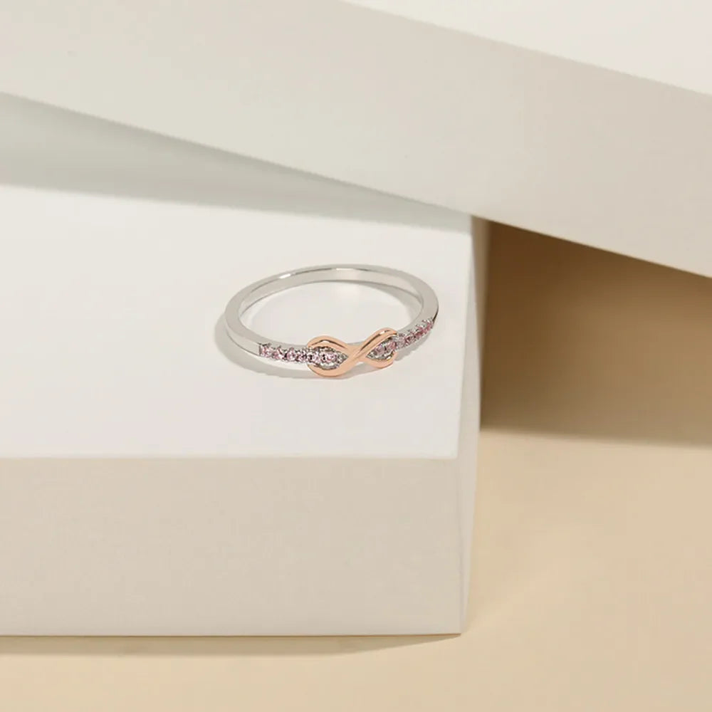 Infinity knot ring with pink stones and rose gold detail on silver band