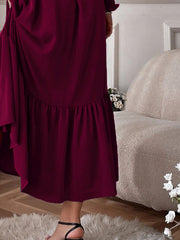 Burgundy midi dress with smocked ruffle hem and flowy skirt detail.