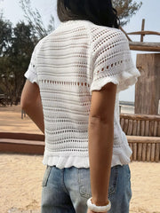 White knit top with openwork pattern, ruffled hem, and short sleeves.