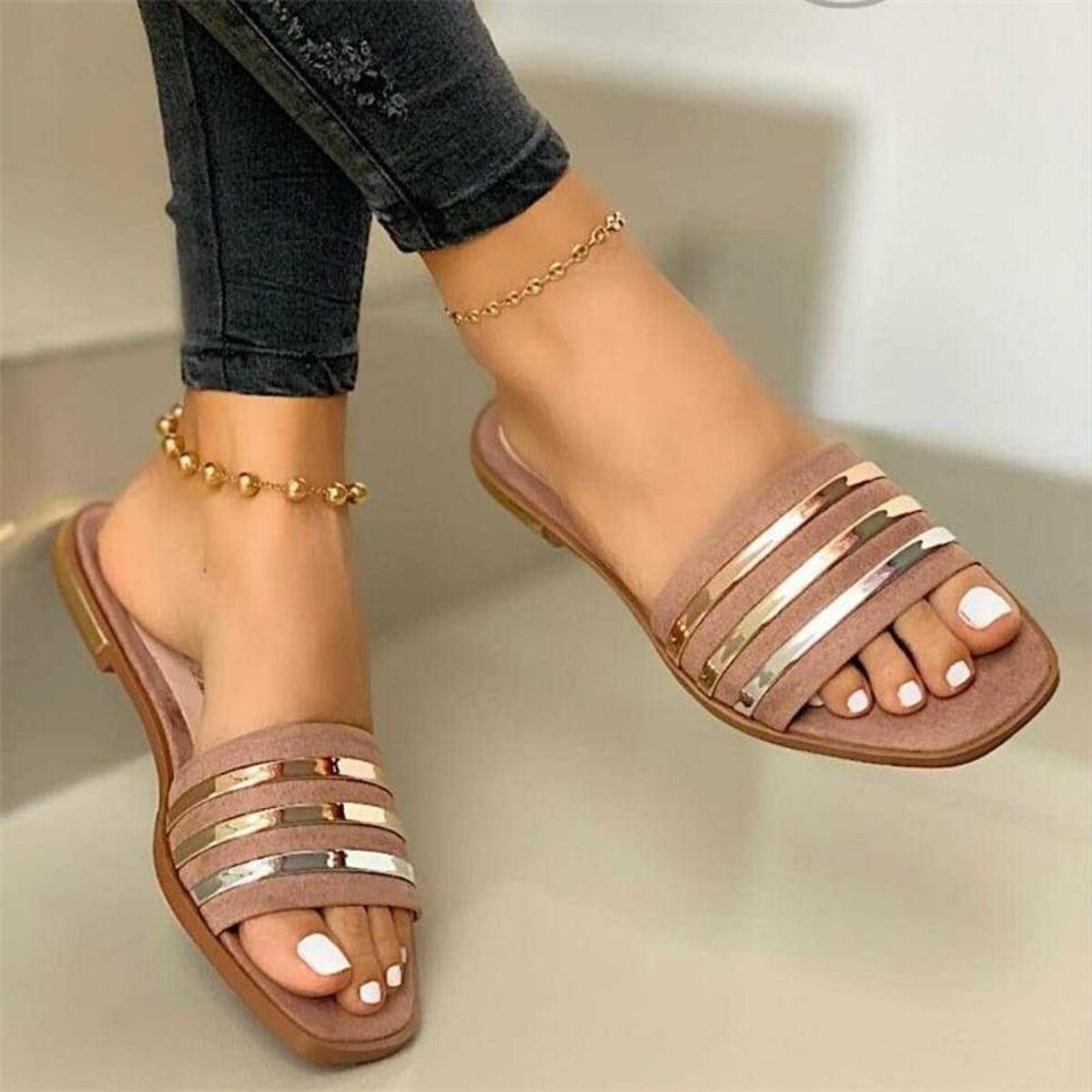 Beige open-toe flat sandals with metallic stripes and square toe.