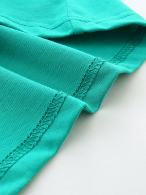 Teal cotton t-shirt detail showing crew neck and short sleeve seam with zigzag stitching.