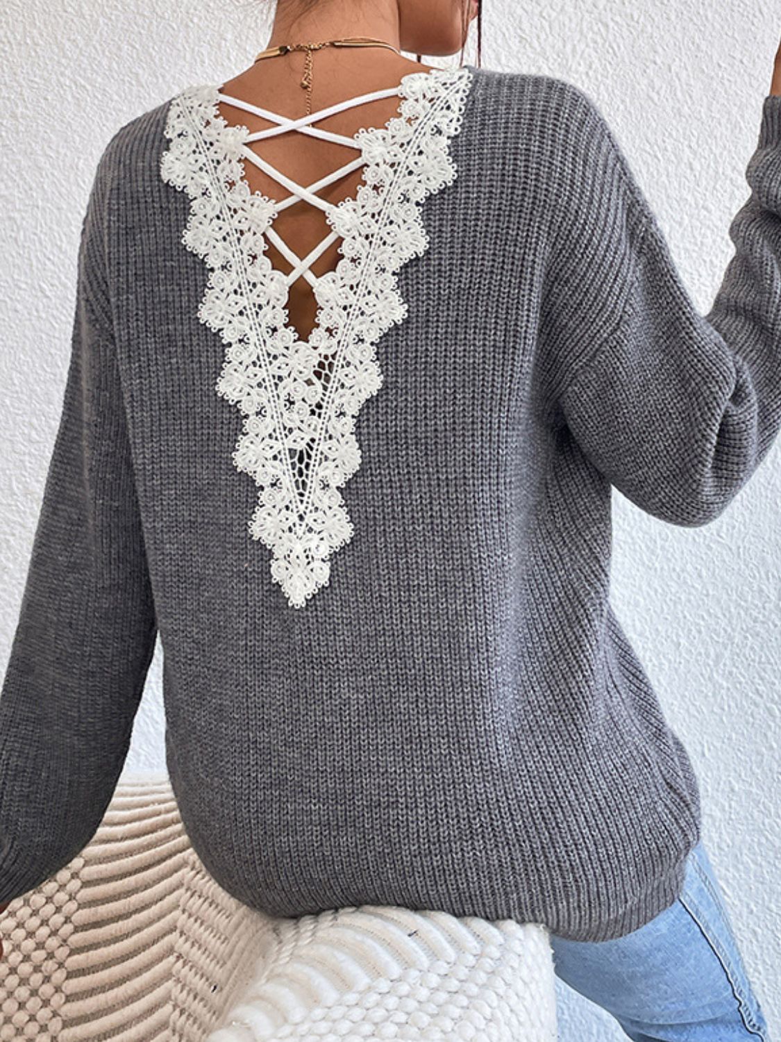 Gray ribbed knit sweater with white lace back detail and criss-cross straps.