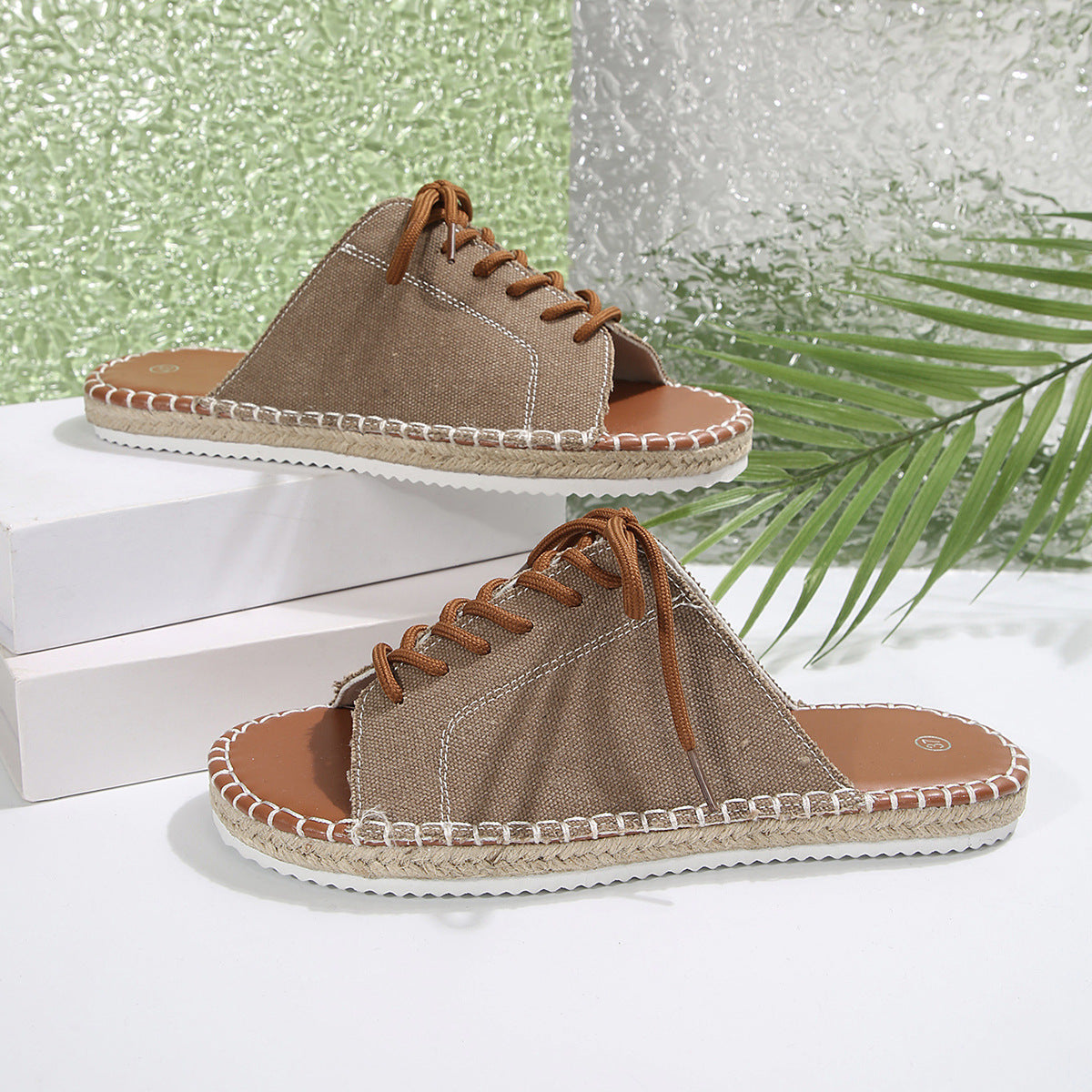 Khaki canvas lace-up open-toe flats with espadrille sole and brown laces.