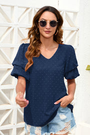 Dark blue Swiss dot blouse with tiered short sleeves and V-neck.