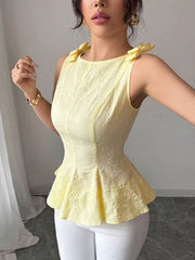 Yellow sleeveless peplum tank top with bow shoulder details and floral texture.