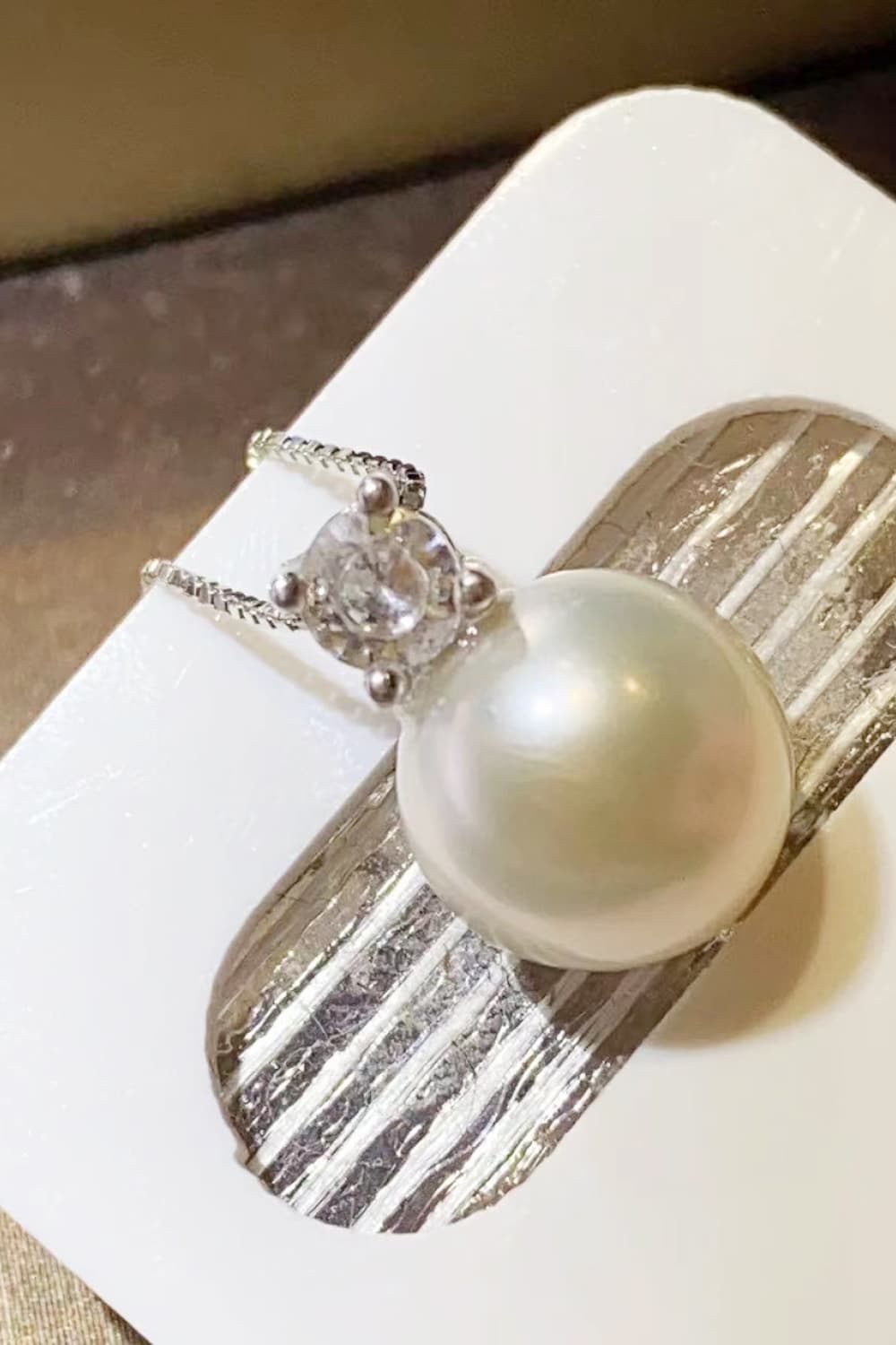 Solitaire pearl pendant necklace in silver with a cubic zirconia accent.