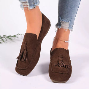 Brown suede slip-on loafers with tassel detail and ankle bracelet