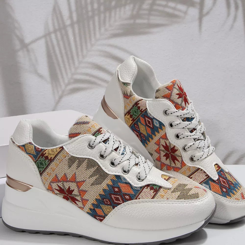 Geometric patterned wedge sneakers in white with colorful Aztec print fabric and a chunky sole.