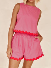 Fuchsia pink scalloped edge tank and shorts set with red trim.