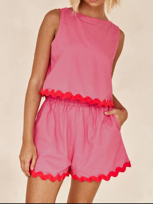 Fuchsia pink scalloped edge tank and shorts set with red trim.