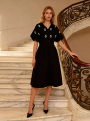 Black midi dress with puff sleeves and rhinestone embellishments.