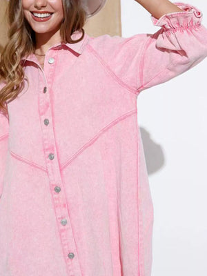 Blush pink denim button-down dress with ruffled cuffs and contrast stitching.