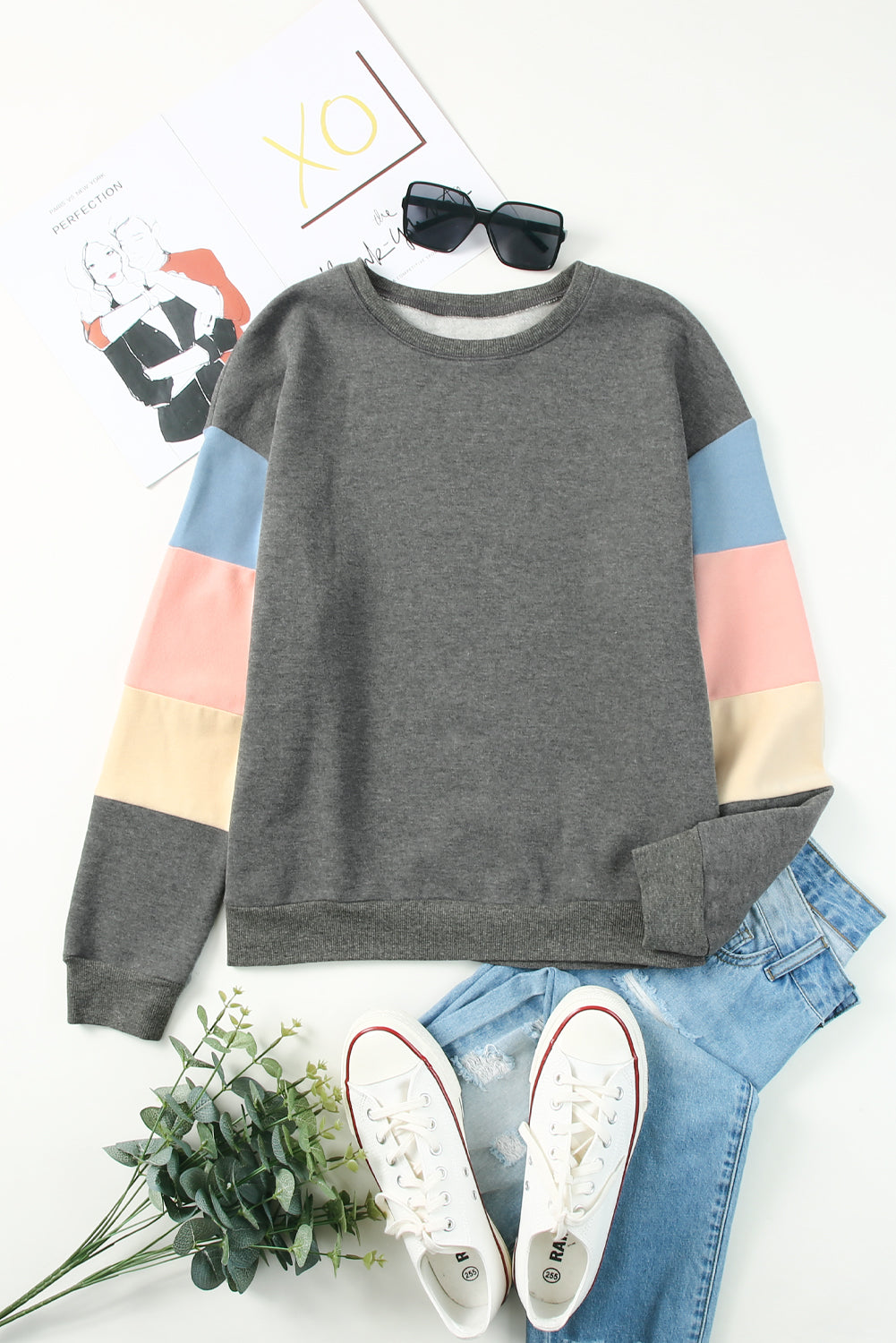 Gray sweatshirt with color block sleeves in pink, blue, and cream.