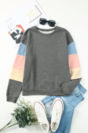 Gray sweatshirt with color block sleeves in pink, blue, and cream.