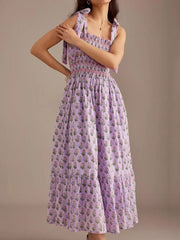 Lilac floral midi dress with smocked bodice and tie shoulders.