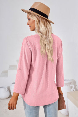 Pink textured henley blouse with rolled sleeves and a relaxed fit.