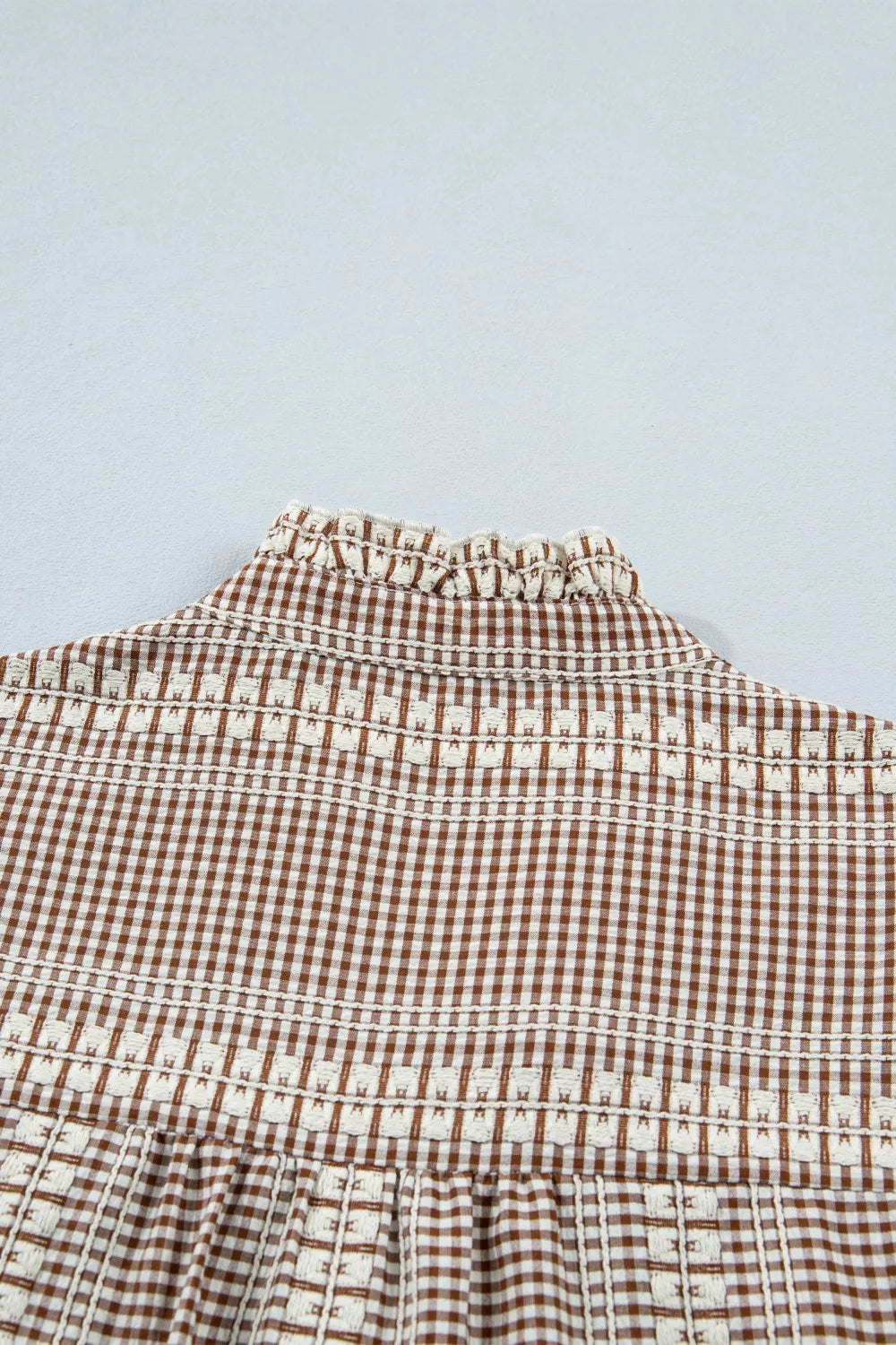 Brown gingham maternity shirt with embroidered yoke and ruffled neckline.