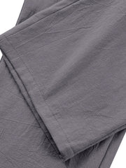 Grey relaxed fit sweatpants with pleated detail and textured fabric.