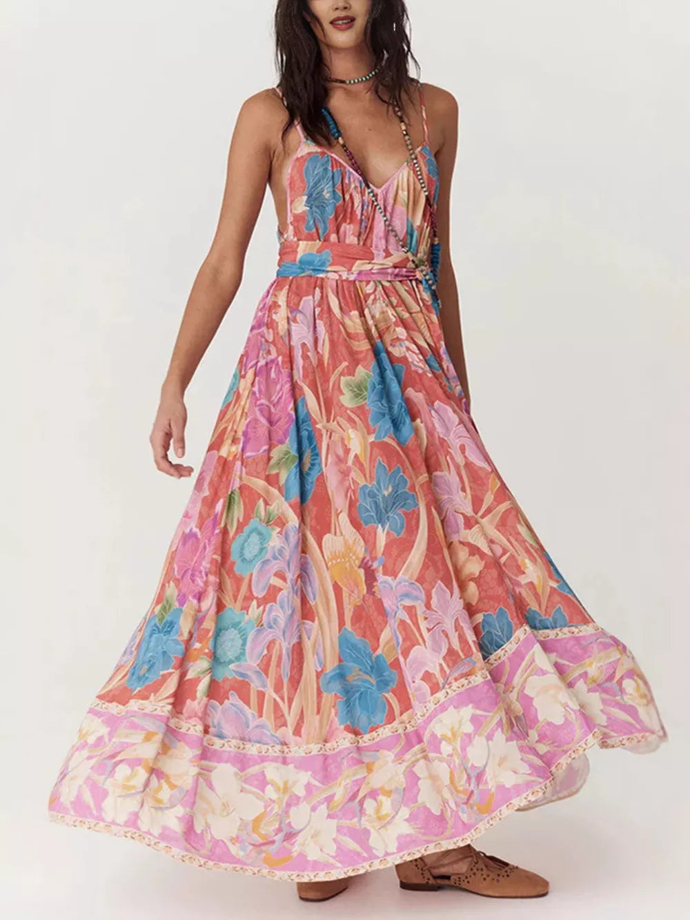 Maxi dress with spaghetti straps and a vibrant floral print in coral, blue, and pink.