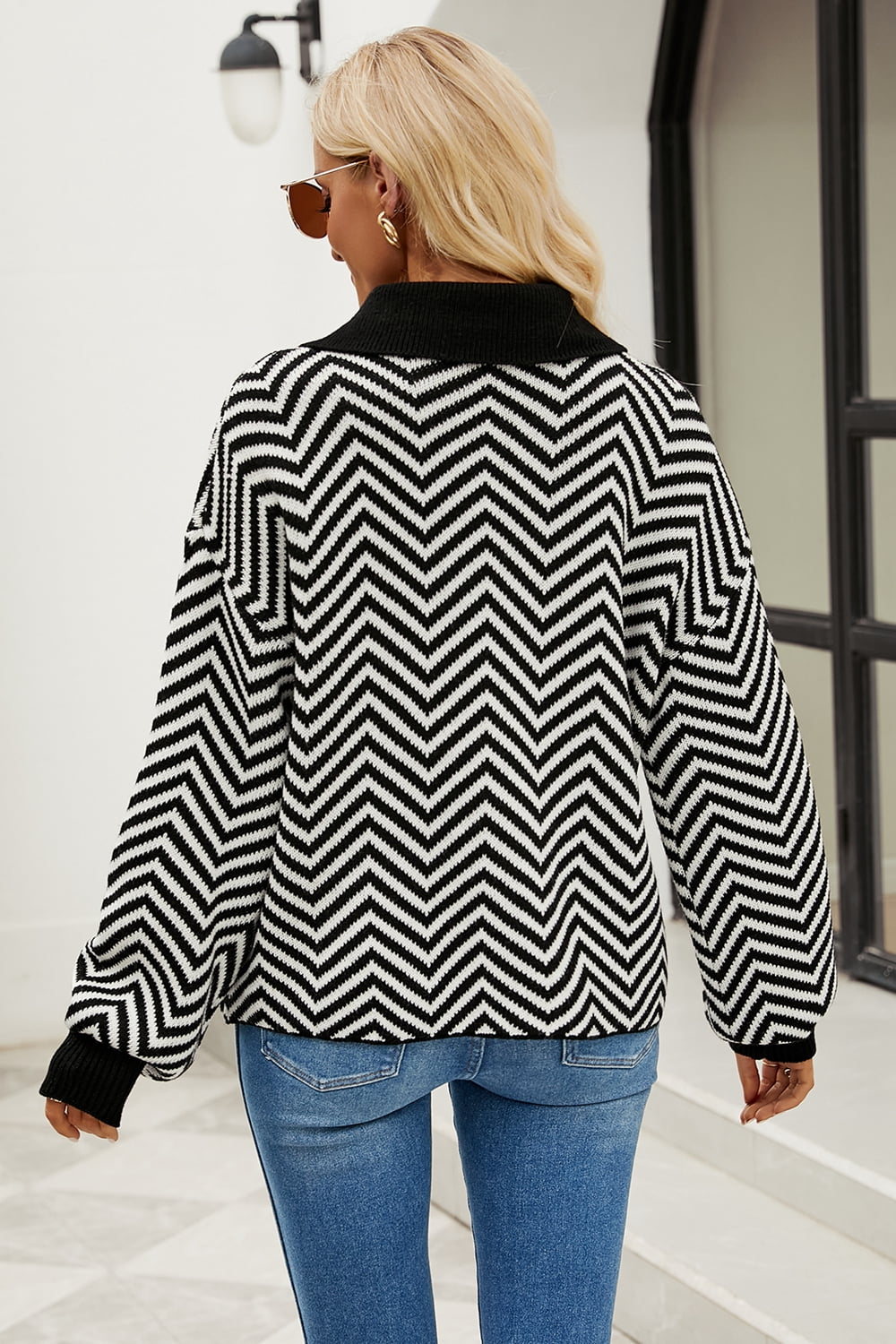 Chevron knit polo sweater in black and white acrylic with a buttoned collar.
