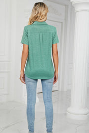 V-neck polo shirt in teal with short sleeves and a pocket detail.